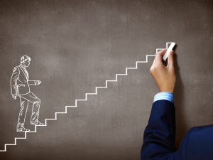 Person climbing stairs drawn on a chalkboard by a person