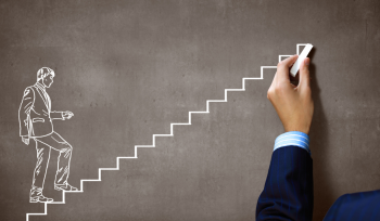 Person climbing stairs drawn on a chalkboard by a person